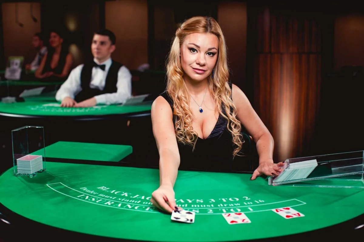 Tampilan ruang kasino live dengan dealer dan meja permainan